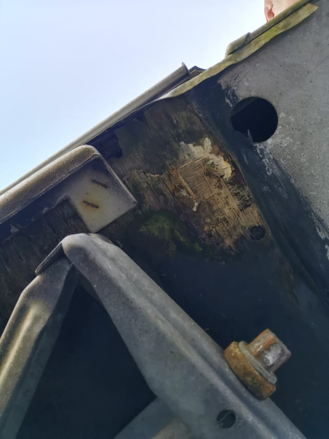 Mørke fugtskader ved gulvet omkring indgangspartiet i en campingvogn