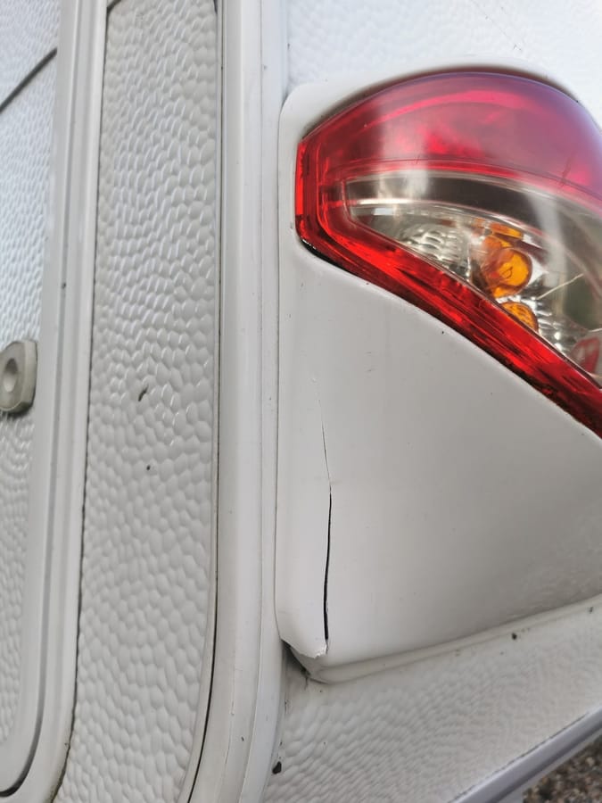 Revne i plastikken ved baglygten på en campingvogn